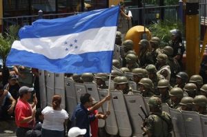 Supporters of ousted Honduras' President Manuel Zelaya protest outside the entrance to the international airport in Tegucigalpa, Sunday, July 5, 2009. After the Organization of American States, OAS, suspended Saturday night Honduras' participation in the organization because of last week coup, Zelaya took off for home Sunday in a Venezuelan jet in a high-stakes attempt to return to power, even as the interim government told its military to turn away the plane. (AP Photo/Dario Lopez-Mills)