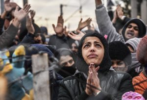 Migrants protest behind a fence against restrictions limiting passage at the Greek-Macedonian border, near Gevgelija, on December 1, 2015. Since last week, Macedonia has restricted passage to northern Europe to only Syrians, Iraqis and Afghans who are considered war refugees. All other nationalities are deemed economic migrants and told to turn back. Macedonia on November 29 finished building a fence on its frontier with Greece becoming the latest country in Europe to build a border barrier aimed at checking the flow of migrants. / AFP / ARMEND NIMANI (Photo credit should read ARMEND NIMANI/AFP/Getty Images)